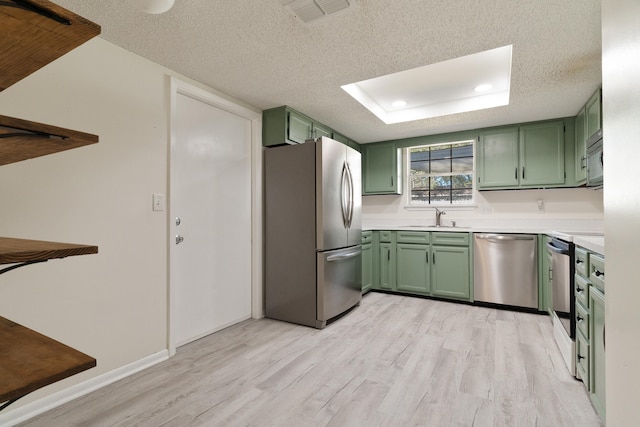 kitchen featuring green cabinets, sink, a textured ceiling, and appliances with stainless steel finishes