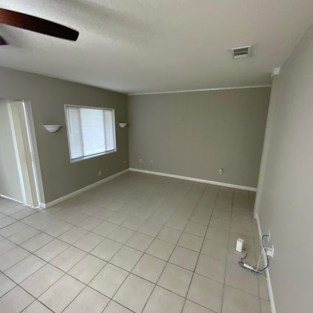 tiled spare room featuring a textured ceiling