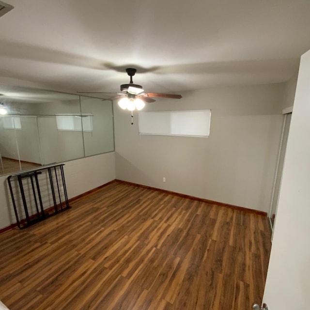 unfurnished room featuring ceiling fan and dark wood-type flooring