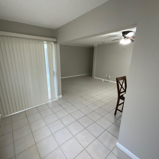 empty room with ceiling fan and light tile patterned floors