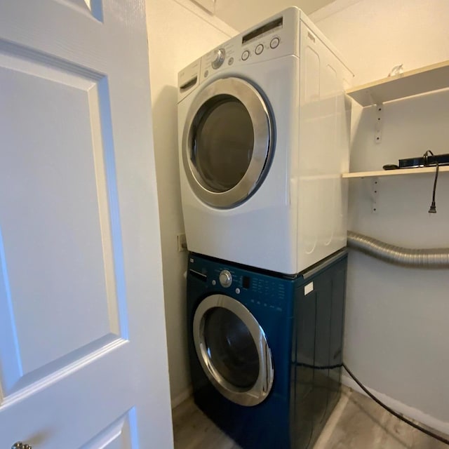 clothes washing area featuring stacked washer / dryer