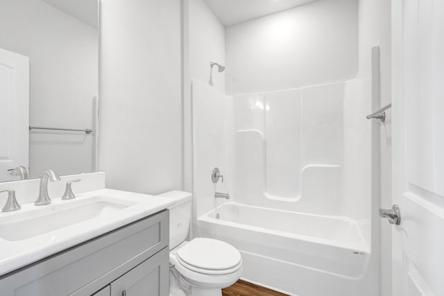 full bathroom featuring hardwood / wood-style floors, vanity, toilet, and  shower combination