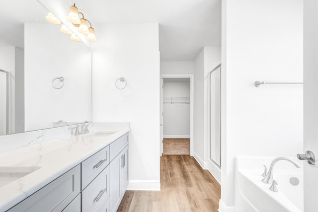 bathroom with independent shower and bath, vanity, and wood-type flooring