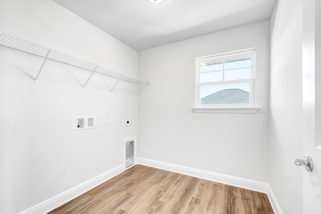 clothes washing area with hookup for a washing machine, light hardwood / wood-style floors, and hookup for an electric dryer