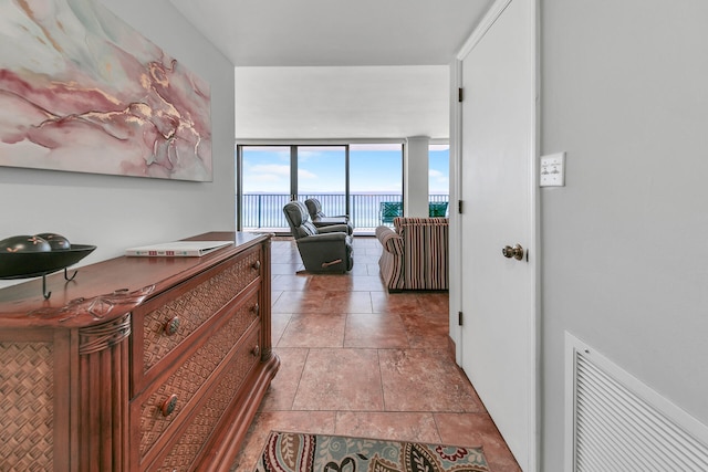 corridor featuring floor to ceiling windows and light tile patterned flooring