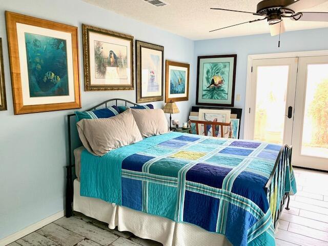 bedroom with ceiling fan and a textured ceiling