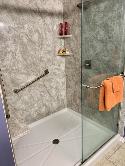 bathroom featuring an enclosed shower and tile patterned floors