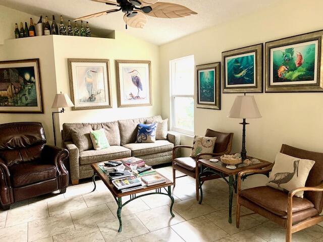 living room with ceiling fan and lofted ceiling