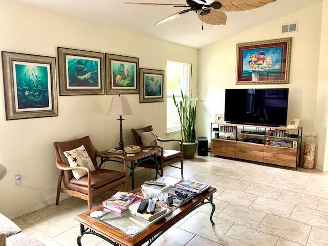 living room with ceiling fan and lofted ceiling