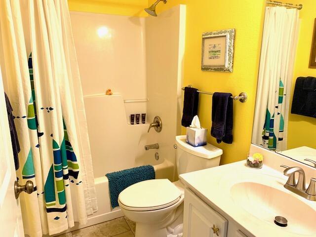 full bathroom featuring toilet, vanity, tile patterned floors, and shower / bath combination with curtain