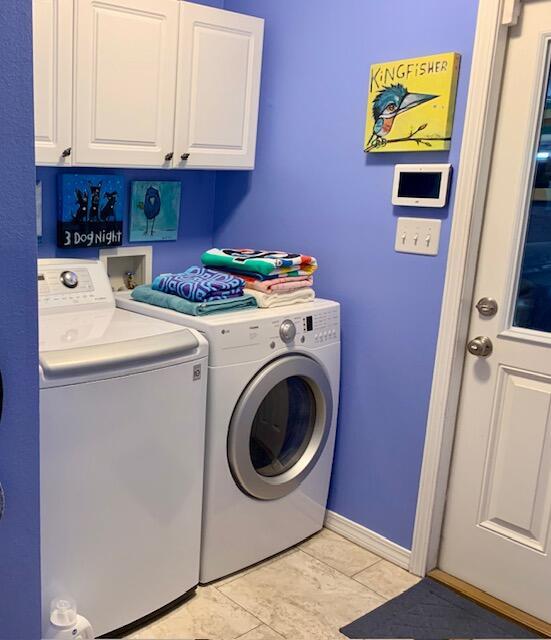 washroom featuring cabinets, light tile patterned floors, and independent washer and dryer