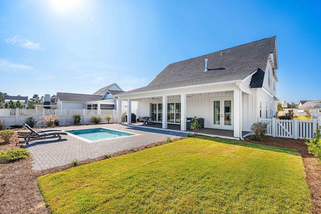 view of pool with a lawn, french doors, and a patio