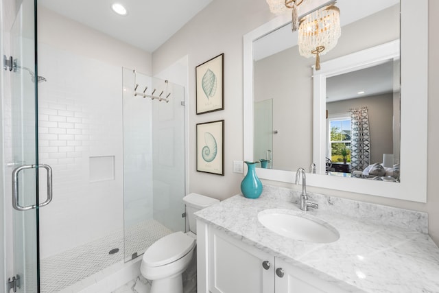 bathroom featuring vanity, toilet, a shower with shower door, and a chandelier