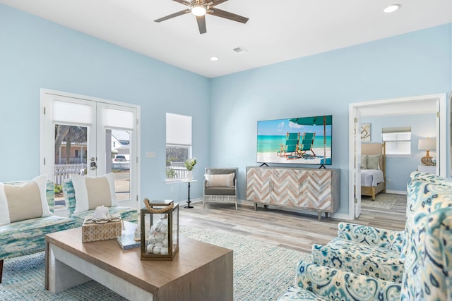 living area featuring baseboards, visible vents, wood finished floors, and french doors