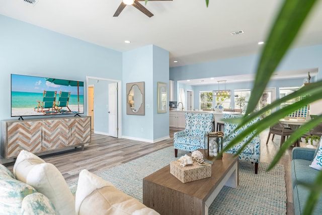 living area featuring recessed lighting, visible vents, light wood-style flooring, and baseboards