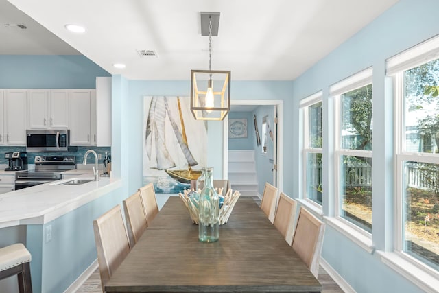 dining space with stairway, baseboards, visible vents, and a chandelier