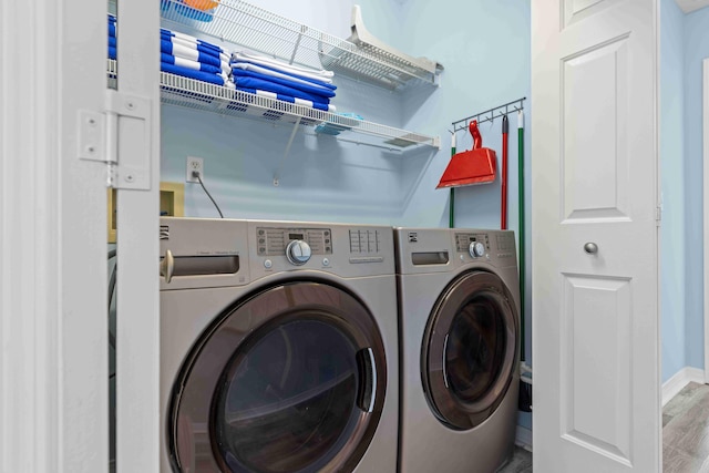 clothes washing area featuring laundry area, separate washer and dryer, and wood finished floors