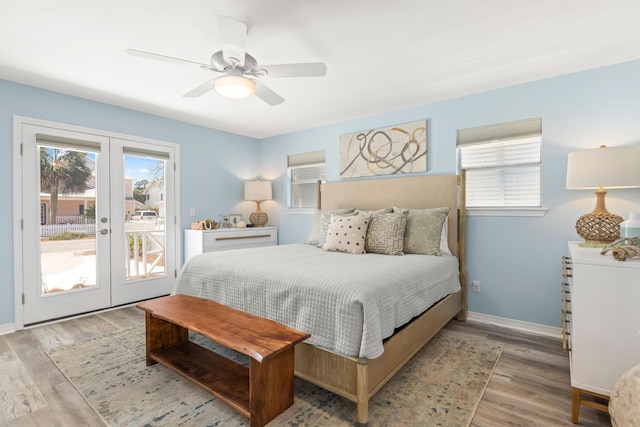 bedroom featuring access to exterior, french doors, multiple windows, and wood finished floors