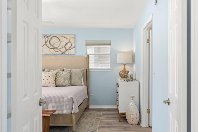 bedroom with baseboards and wood finished floors