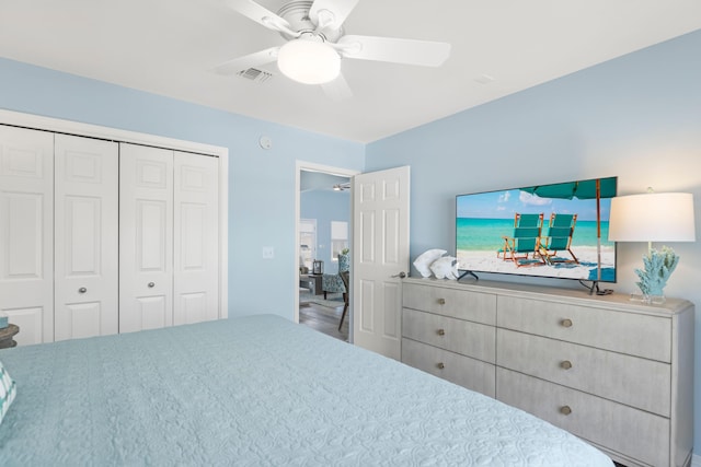 bedroom with ceiling fan, visible vents, and a closet