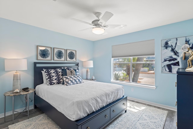 bedroom featuring light wood finished floors, a ceiling fan, and baseboards