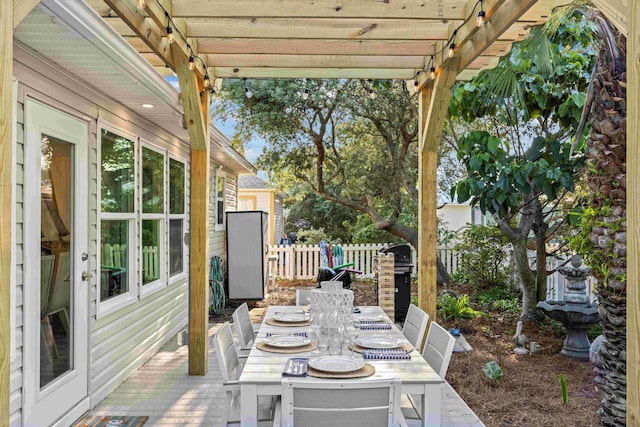 view of patio featuring outdoor dining space, fence, and a pergola