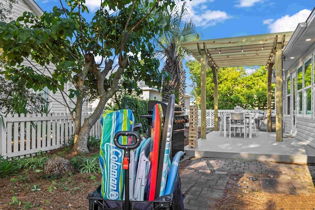 view of patio with outdoor dining space, fence, and a pergola