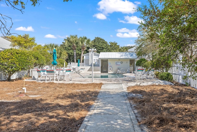 exterior space with a patio area, a community pool, and fence