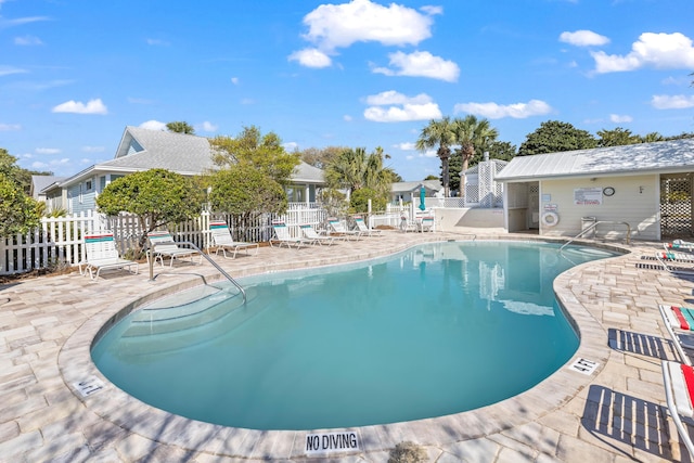 pool with a patio and fence