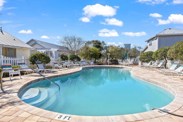 community pool featuring a patio area and fence