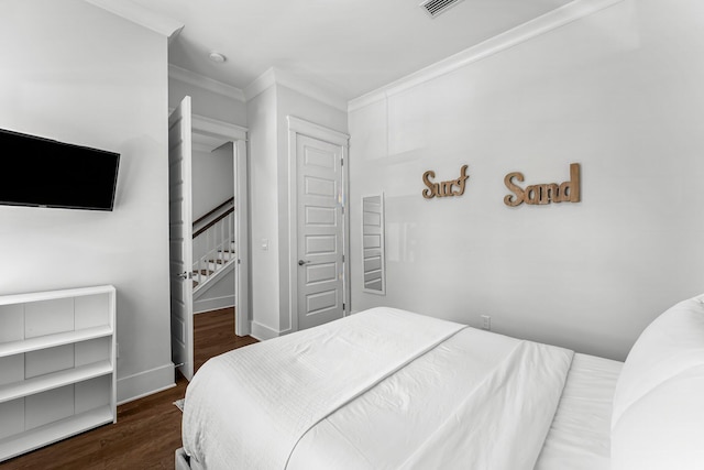 bedroom with ornamental molding, a closet, and dark hardwood / wood-style floors