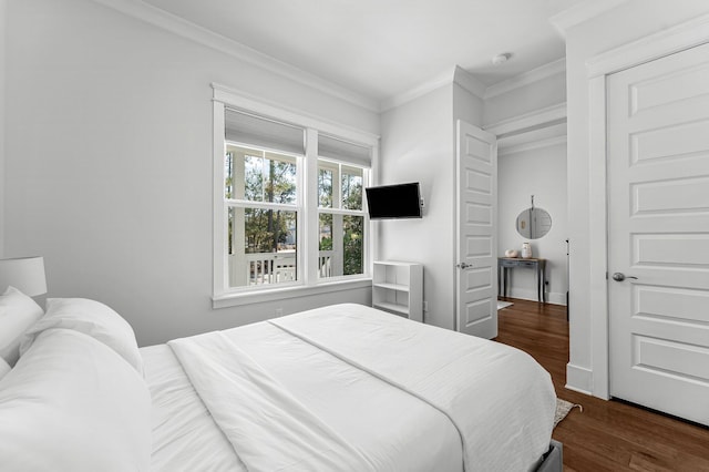 bedroom with dark hardwood / wood-style flooring and crown molding