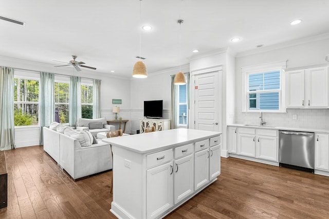 kitchen featuring dishwasher, ceiling fan, a kitchen island, white cabinets, and decorative light fixtures