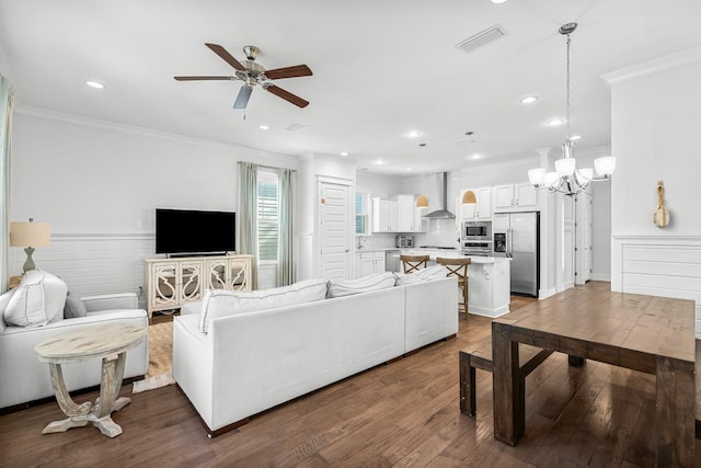 living room with ornamental molding, hardwood / wood-style floors, and ceiling fan with notable chandelier