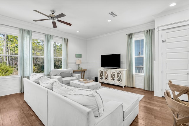 living room with hardwood / wood-style flooring, ceiling fan, and ornamental molding