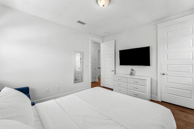 bedroom with dark hardwood / wood-style flooring