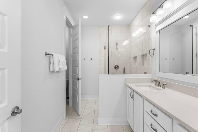 bathroom with tiled shower and vanity