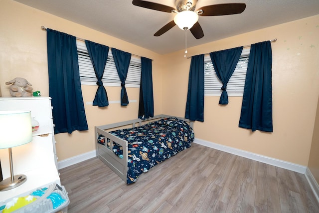 bedroom featuring wood-type flooring, ceiling fan, and a textured ceiling