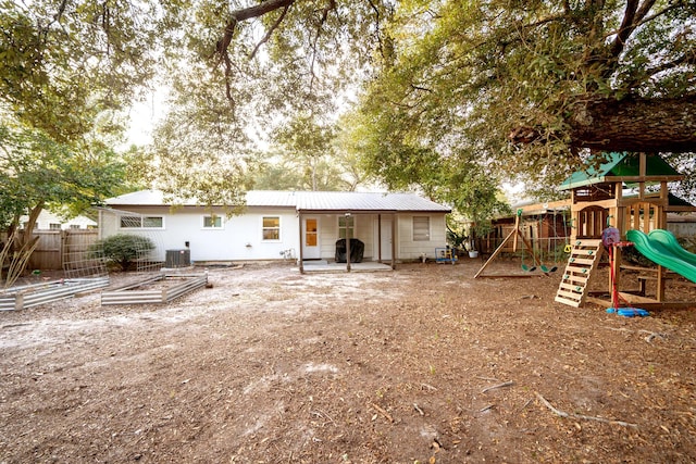 back of property featuring cooling unit and a playground