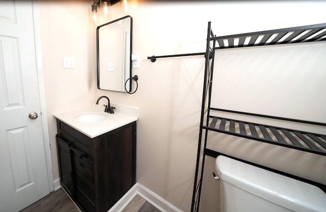 bathroom with hardwood / wood-style flooring, vanity, and toilet