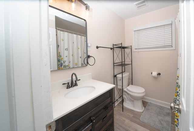 bathroom featuring vanity, toilet, and wood-type flooring