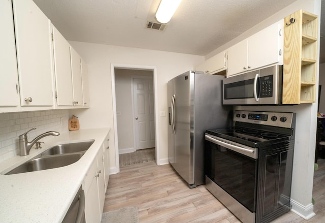 kitchen with white cabinetry, sink, backsplash, and stainless steel appliances