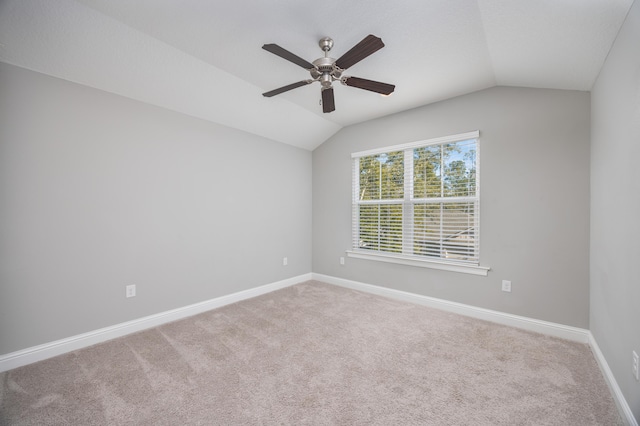 carpeted empty room with ceiling fan and vaulted ceiling