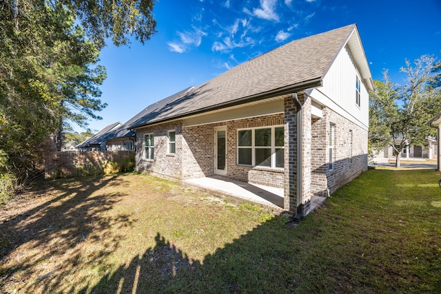 back of house with a patio area and a yard