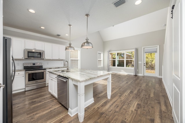 kitchen featuring sink, white cabinetry, stainless steel appliances, and an island with sink