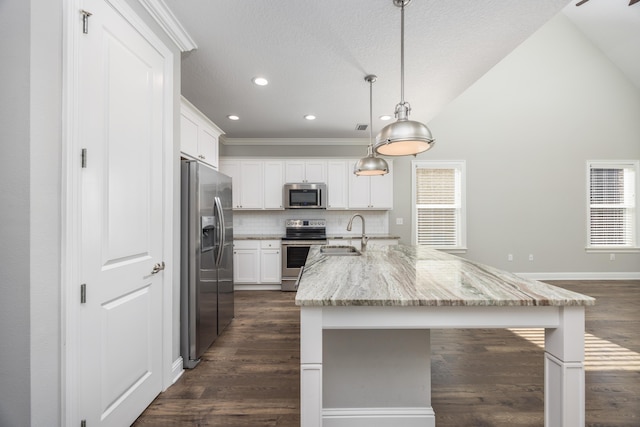 kitchen with sink, stainless steel appliances, light stone counters, pendant lighting, and white cabinets