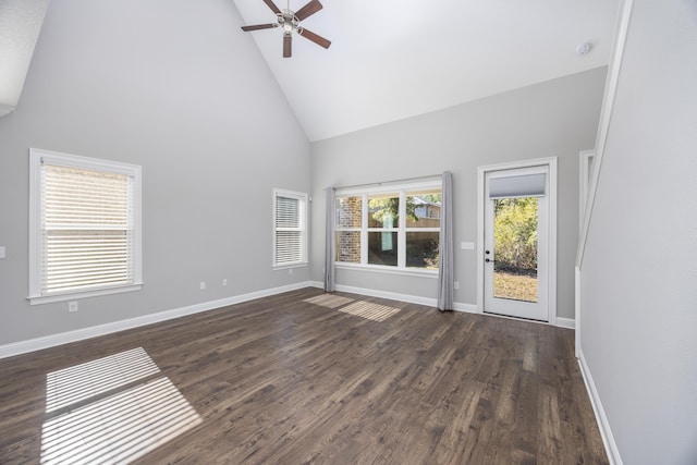 unfurnished living room featuring ceiling fan, high vaulted ceiling, a healthy amount of sunlight, and dark hardwood / wood-style floors