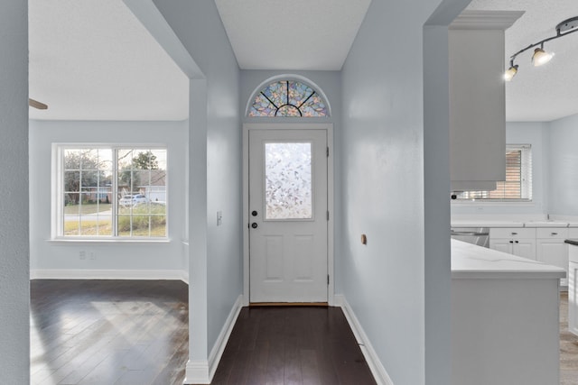 foyer with a textured ceiling and dark hardwood / wood-style floors