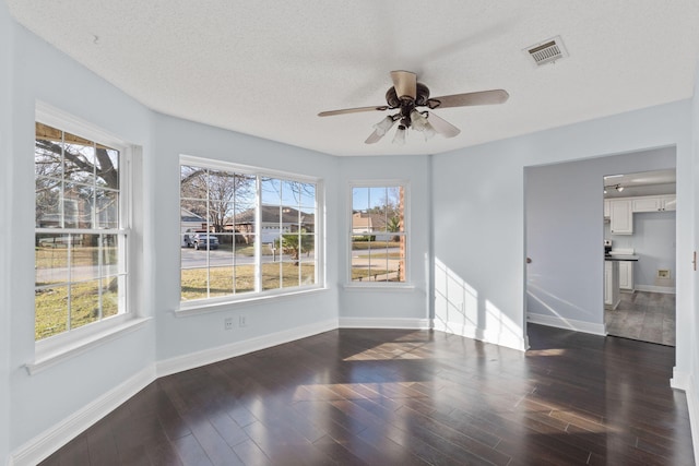 unfurnished room with dark hardwood / wood-style flooring, a textured ceiling, and ceiling fan