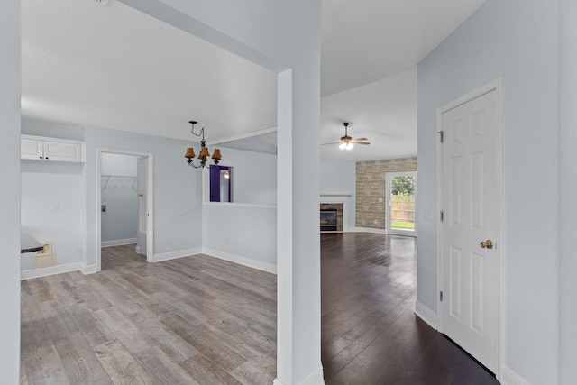 interior space featuring wood-type flooring and ceiling fan with notable chandelier